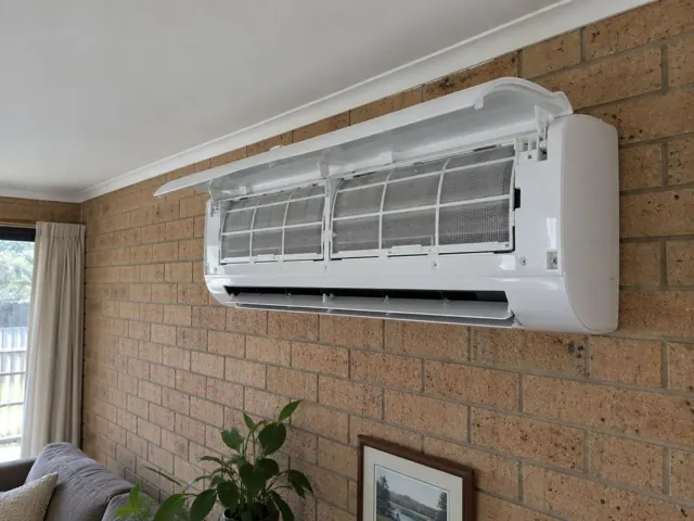 Clean split system indoor head with open front panel and visible filters on a brick wall in Elizabeth Park